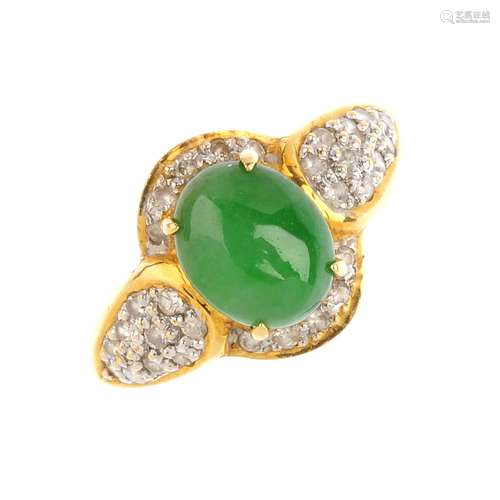 A jade and diamond dress ring. The oval jadeite cabochon, with brilliant-cut diamond curved surround