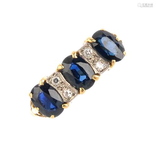 An 18ct gold sapphire and diamond dress ring. The oval-shape sapphire line, with twin single-cut