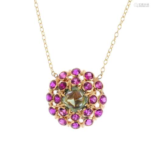 A gem-set pendant. The square green gem cabochon, with circular-shape ruby collet surround,