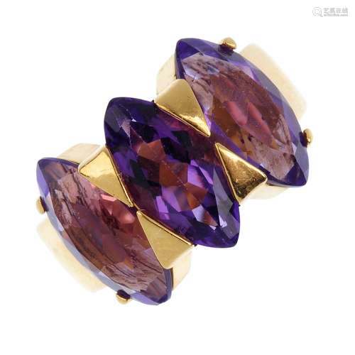 An amethyst three-stone ring. The marquise-shape amethyst line, with triangle double spacers and