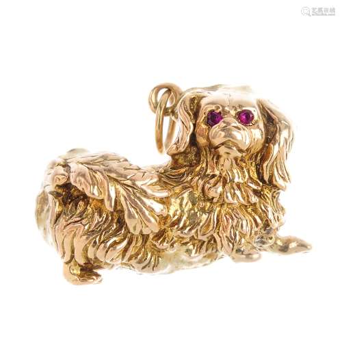 A dog charm. Designed as a textured Pekingese dog, with circular-shape ruby eyes. Length 2.5mms.