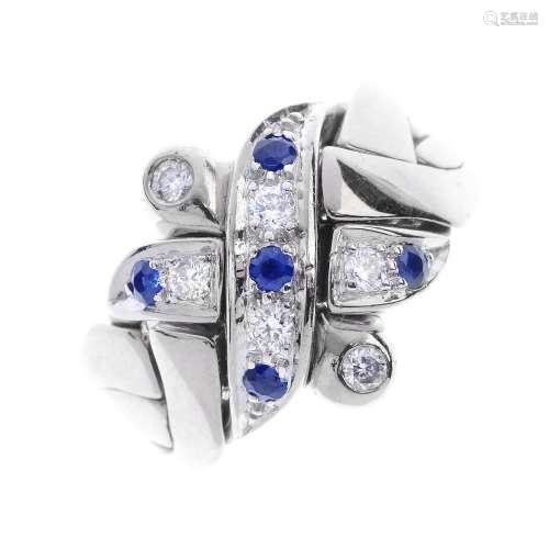 A sapphire and diamond puzzle ring. Designed as four interlocking rings, with brilliant-cut