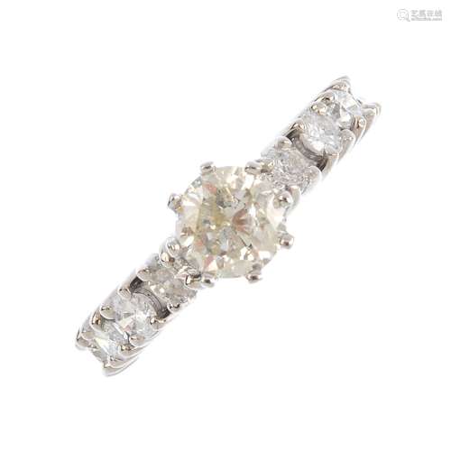 A diamond single-stone ring. The brilliant-cut diamond, with similarly-cut diamond line shoulders.