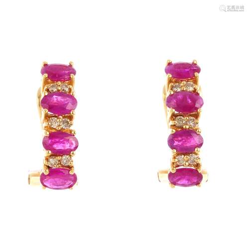 Apair of ruby and diamond earrings. Each designed as a series of four oval-shape rubies, with