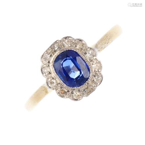A sapphire and diamond cluster ring. The oval-shape sapphire, with single-cut diamond scalloped