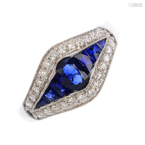 An 18ct gold sapphire and diamond dress ring. The oval-shape sapphire, with calibre-cut sapphire