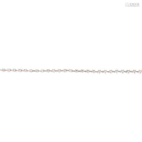 An 18ct gold diamond bracelet. The brilliant-cut diamond line, with textured bar spacers and