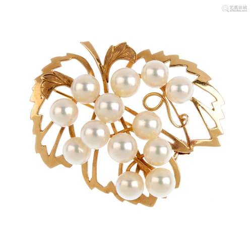 A cultured pearl brooch. Designed as a bunch of cultured pearl grapes, atop the pierced vine leaves.