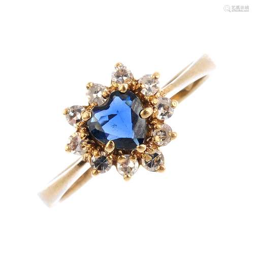 A 9ct gold sapphire and diamond cluster ring. The heart-shape sapphire, with single-cut diamond