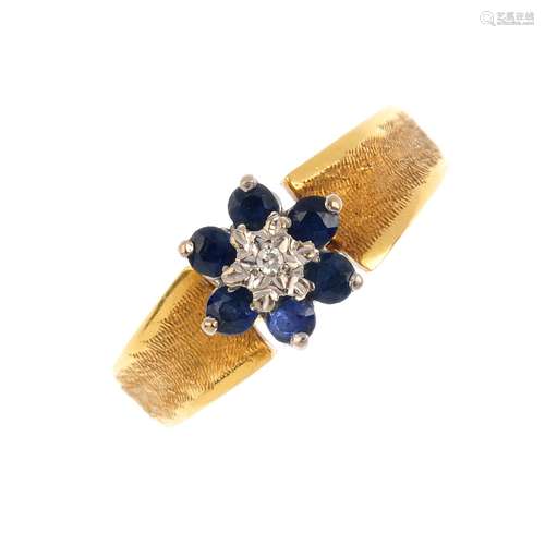 A sapphire and diamond cluster ring. The circular-shape sapphire floral cluster, with single-cut