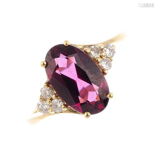 A 9ct gold garnet and diamond dress ring. The oval-shape garnet, with single-cut diamond trefoil