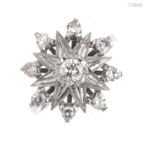 A diamond cluster ring. The brilliant-cut diamond, within a star setting, with circular-cut