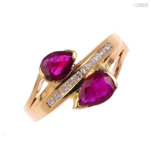 A ruby and diamond dress ring. Of cross-over design, the pear-shape ruby terminals with central