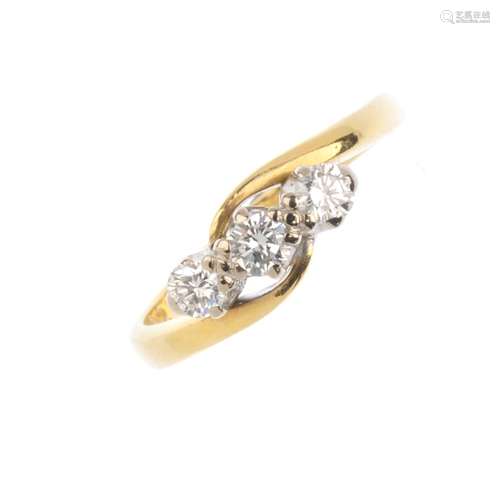 An 18ct gold diamond three-stone ring. Designed as a brilliant-cut diamond off-set line, with