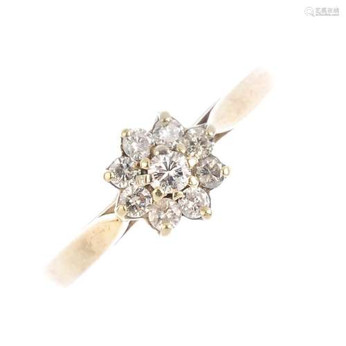 A 9ct gold diamond cluster ring. The brilliant-cut diamond, with a similarly-cut diamond surround.