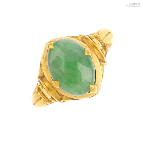 A jade dress ring. The oval jadeite cabochon, with embossed and applied foliate shoulders and sides.