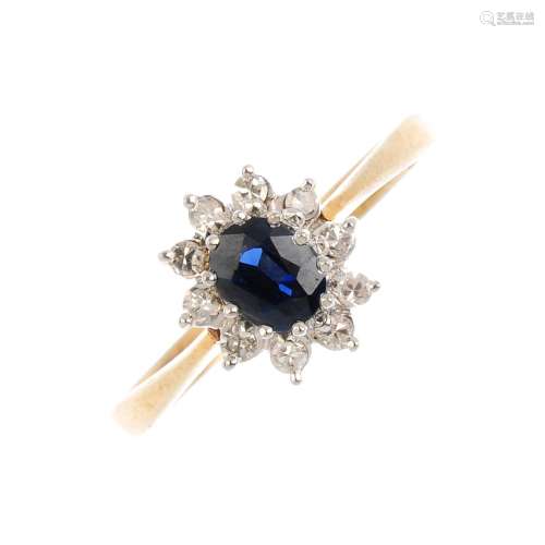 A 9ct gold sapphire and diamond cluster ring. The oval-shape sapphire, with single-cut diamond