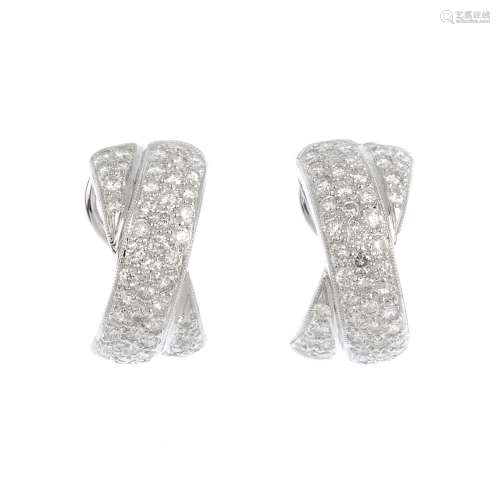 A pair of 18ct gold diamond earrings. Each designed as a pave-set diamond crossover half-hoop. Total