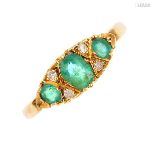 An 18ct gold emerald and diamond dress ring. The graduating oval and circular-shape emeralds, with