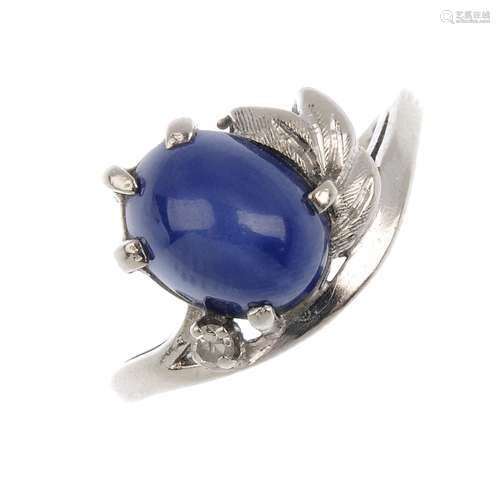 A synthetic star sapphire and diamond ring. The oval synthetic six-ray star sapphire cabochon,