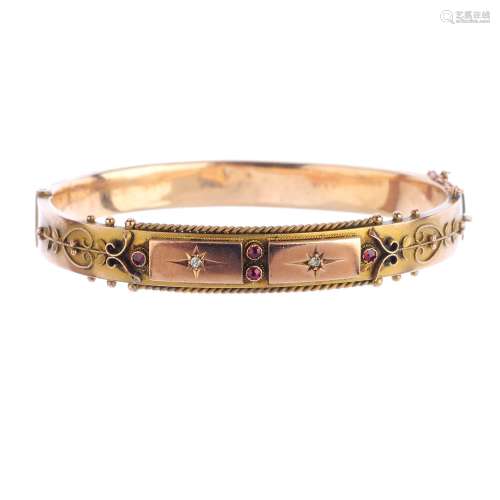 An Edwardian 9ct gold gem-set hinged bangle. Designed as two star-set old-cut diamond panels, with