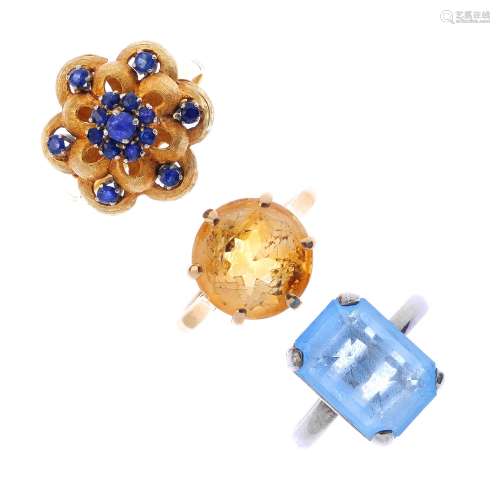 Three gem-set rings. To include a 9ct gold yellow gem single-stone ring, a sapphire floral cluster