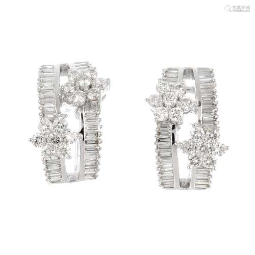 A pair of 18ct gold diamond earrings. Each designed as two brilliant-cut diamond floral clusters,