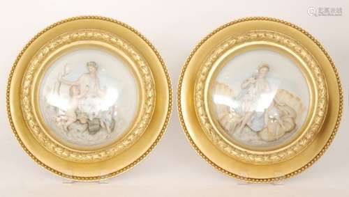 A pair of early 20th Century continental circular bisque plaques, each with relief moulded scenes of a mother and child, the first harvesting grapes, the second the child asleep on the hay, both within gilt frames and behind domed glass, unmarked, diameter 45cm