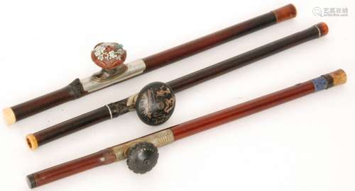 A Chinese opium pipe with stained bamboo stem, natural knot and signed pottery bowl, length 57cm, a similar pipe with blue enamelled mounted character collar, length 55cm and another opium pipe with painted pottery bowl mounted with a frog, length 56cm (3)