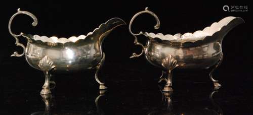 A pair of George III hallmarked silver cream boats each with scalloped edge rim, leaf capped flying scroll handles and raised on three hoof feet total weight 10.4oz, London 1771, William Cattell (2)