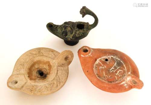 A Roman terracotta oil lamp decorated with an erotic scene and another with leaf border and a bronze Bacchus example (3)