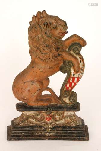 A mid 19th Century cast iron door stop in the form of a rampant lion resting on a scroll armorial shield on stepped acanthus base,