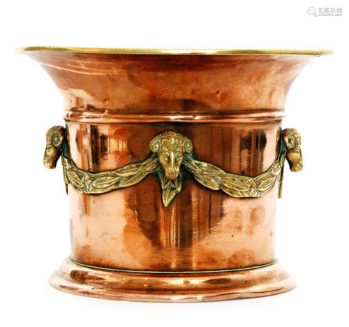 A late 19th to early 20th Century copper vase or jardiniere with flared rim and applied brass laurel swags interspaced with rams heads, diameter 23cm, stamped to base with mark for William Soutter and Sons