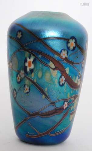 A later 20th Century Okra studio glass vase of shouldered form decorated with stylised flower heads and random cinnamon whiplash lines over the pale teal ground all in a iridescent finish, dated 1984, engraved signature, height 14.5cm.