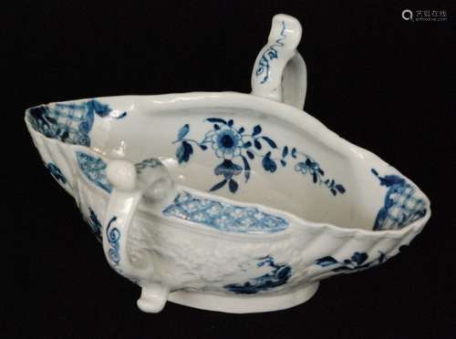 A late 18th Century Worcester twin handled sauce boat decorated with a blue and white hand painted landscape with smaller floral sprays, the exterior with Chinoiserie roundels within moulded garland frames, painters marks to the base otherwise unmarked, length 19.5cm, S/D.