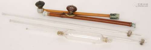 A Chinese opium pipe with bamboo stem grey hardstone mouth piece and speckled mauve bowl, length 49cm, another with white carved hardstone fist and pottery bowl, length 45cm and three glass measuring tubes each with taps, S/D (5)