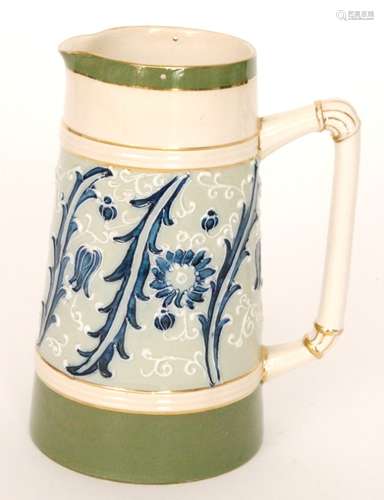 A late 19th Century James Macintyre 'Gesso Faience' water jug decorated in a design by William Moorcroft with tubelined flowers and scrolling foliage in tones of blue against a pale green ground, printed mark, M339 pattern, lacks pewter cover, height 18.5cm