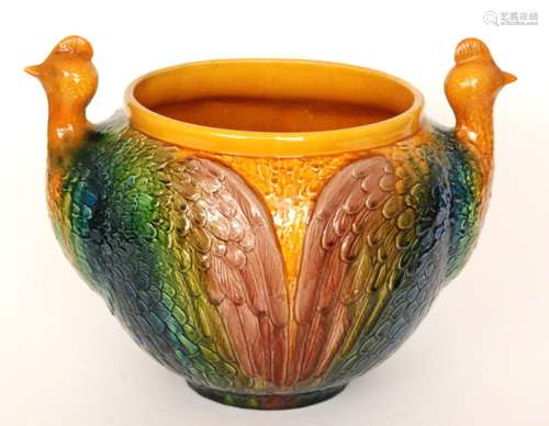 A large early 20th Century Bretby shape 697 jardiniere formed as two cockerel type birds with bright coloured glazed wings against a yellow ground, impressed marks, height 33cm, restored.