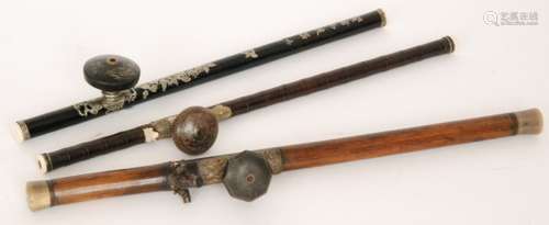 A Chinese opium pipe with bamboo stem, pottery bowl and ivory tips, length 59cm, another pipe the saddle with mythical figures and horn ends and a similar pipe the black stem inlaid with floral decoration and character symbols, length 54cm (3)