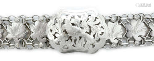 A Continental white metal belt designed as leaf shaped links with pierced frame and shaped rectangular clasp pierced and engraved with a bird, length 89cm