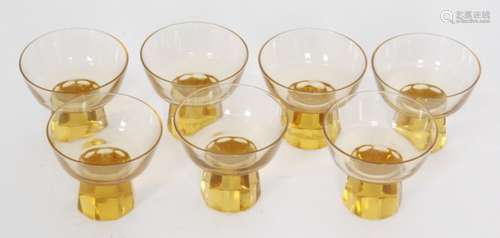 A set of seven 1930s Mazolay liqueur glass, the faceted foot below a wide shallow bowl all to the amber ground, acid marked, height 7cm.