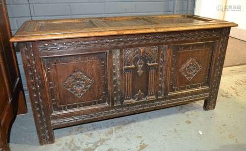 An oak coffer in the 18th Century style, with carved panels and raised to style feet, width 107cm.