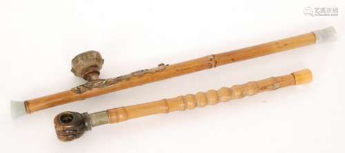 A Chinese opium pipe with bamboo stem and brass fittings, pottery bowl and green hardstone ends, length 55cm, and a similar pipe with brown hardstone carved fist end, length 42cm, both S/D (2)