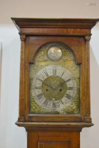 An early 19th Century oak Longcase clock by Joseph Men Blandford, with eight day striking movement silvered chapter ring and date aperature enclosed by a glazed pillared hood aand glazed door over a long trunk door on canted plinth base, height 211cm