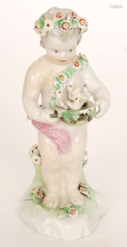 A late 18th to early 19th Century Derby figure of a standing cherub wearing a garland of flowers in his hair and as a sash holding a basket of chicks, unmarked, height 15cm, restored