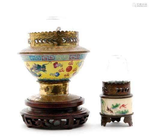 A Chinese opium lamp with glass shade and porcelain body depicting a dragon chasing a pearl on a yellow ground below a Greek key border and a small similar lamp with a signed ivory collar (2)