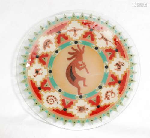 A contemporary slump work glass charger decorated with radial geometric patterns between animals surrounding a central stylised figure playing the flute, unmarked, diameter 29cm.