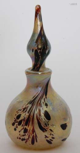 A later 20th Century Okra studio glass scent bottle of globe and shaft form below a drawn spire stopper decorated with brown spotting over the pale yellow ground all in an iridescent finish, dated 1984, engraved signature, height 14cm.