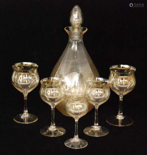 A 1920s Leerdam 'Normaal I' glass suite designed by Cornelis De Lorm comprising a conical form decanter, four red wines, four white wines and four sherry, all picked out in a pale gold to the clear crystal ground, acid marked, decanter height 31cm.