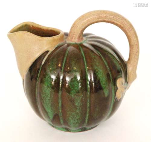An early 20th Century French stoneware jug by Louis Lourioux, of fluted globular form with integral spout and high loop handle with a green and brown glaze to the body, mark to base, height 14.5cm.